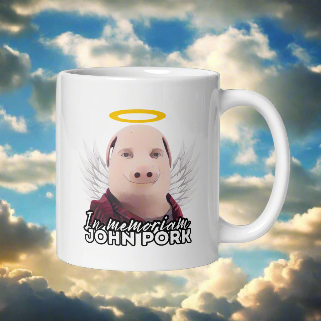 John Pork muki, jossa on enkeli ja teksti 'In memoriam' humoristisella ilmeellä