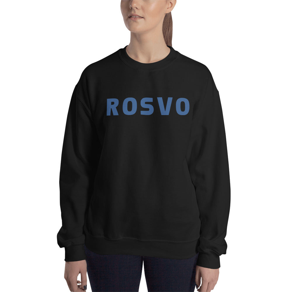Yksinkertaista valkoista taustaa vasten seisoo henkilö, jolla on yllään Meemirottan musta "Rosvo College" collegepaita, jonka etupuolelle on painettu "ROVO" isoilla sinisillä kirjaimilla. Heidän pitkät hiuksensa on sidottu taakse, ja tämä leikkisä vaate lisää vaivattomasti ripaus huumoria heidän tyyliinsä.
