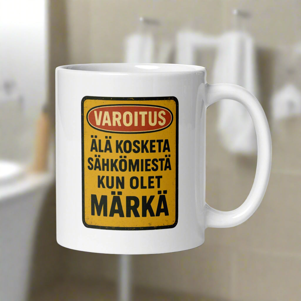 Hauska kahvikuppi varoitusmerkinnällä: älä kosketa sähkölaitteista kun olet märkä